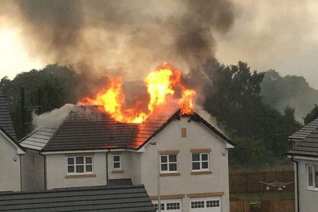 The roof of a detached house stands ablaze following a lightning strike. @impaulharper