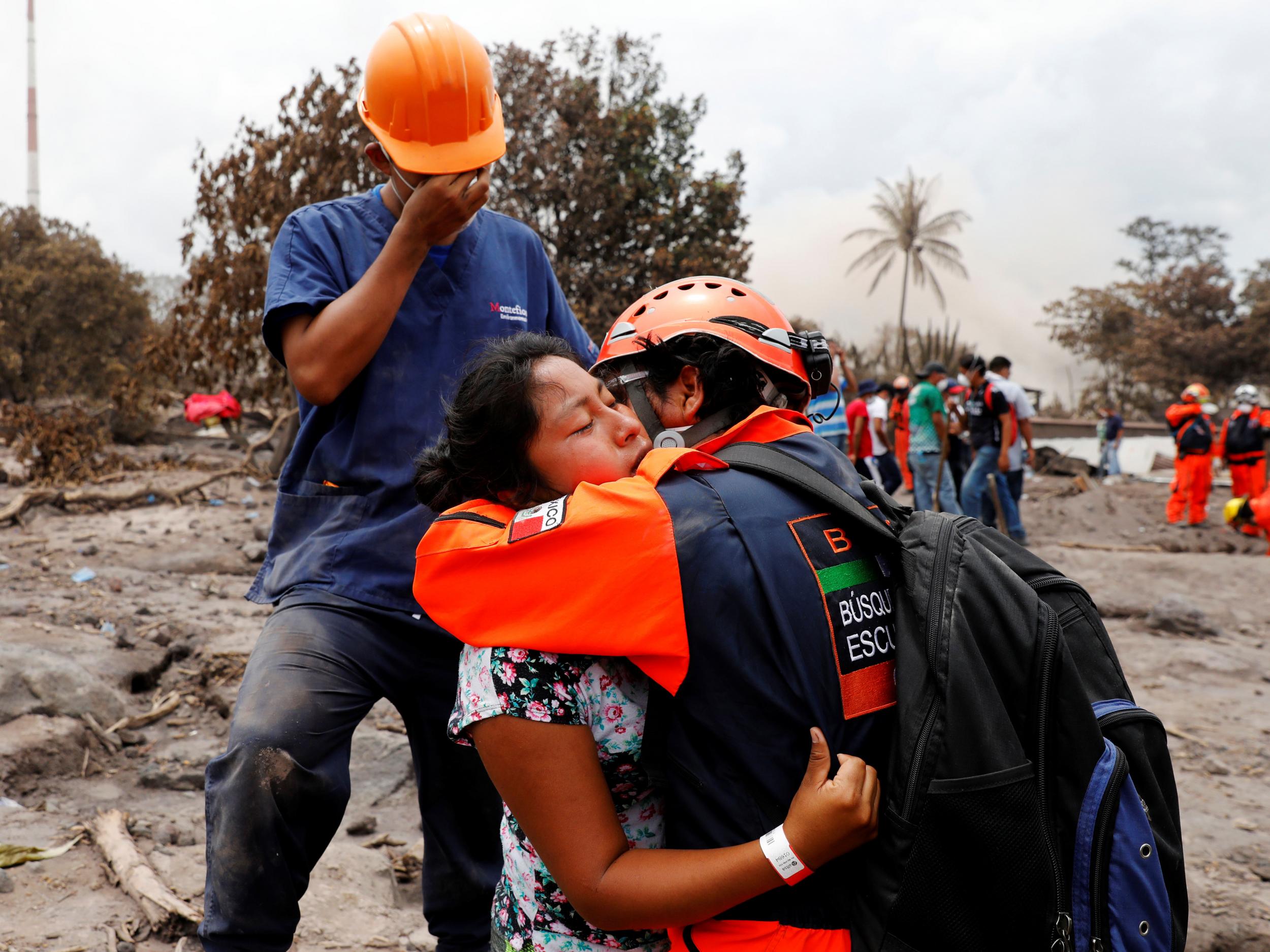 A survivor who is looking for her daughter is comforted by a volunteer after the eruption of the Fuego volcano in Guatemala on June 9 2018.