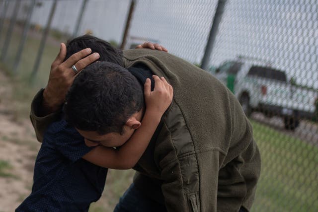 A four-year-old boy weeps in the arms of a family member as they were apprehended by border patrol agents after illegally crossing into the US border from Mexico on 2 May 2018.