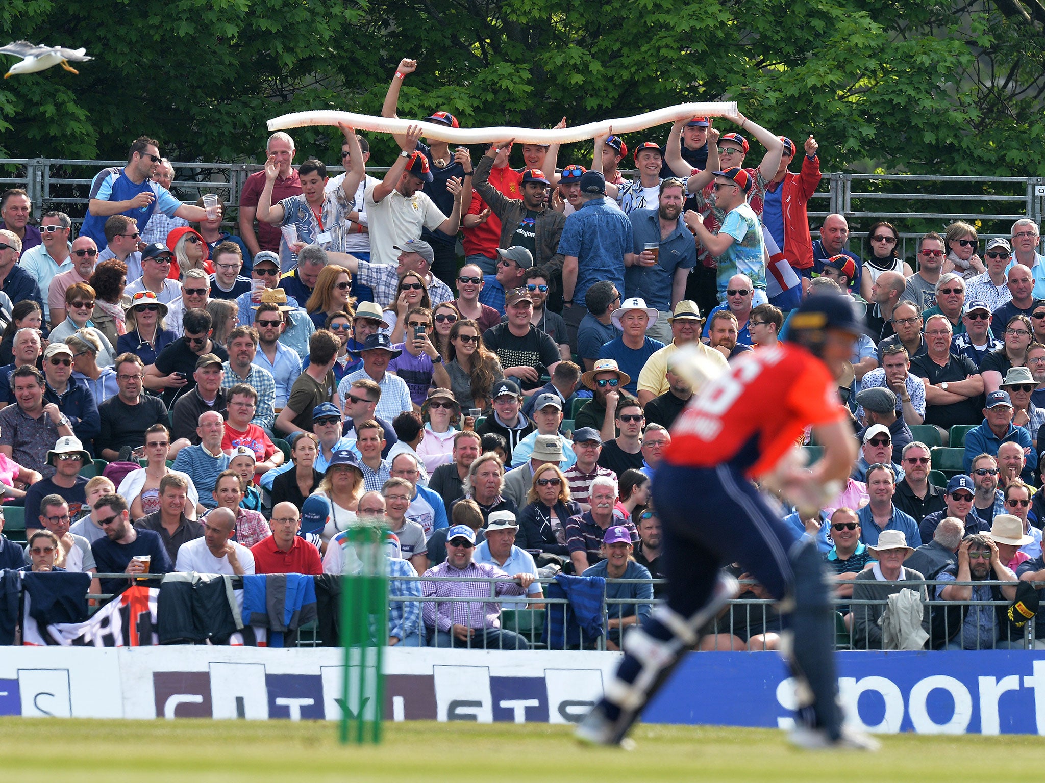 Spectators in the crowd enjoy themselves as they make a snake of beer glasses