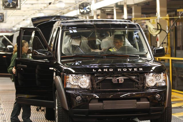 Workers inspect a Land Rover Discovery on the production line