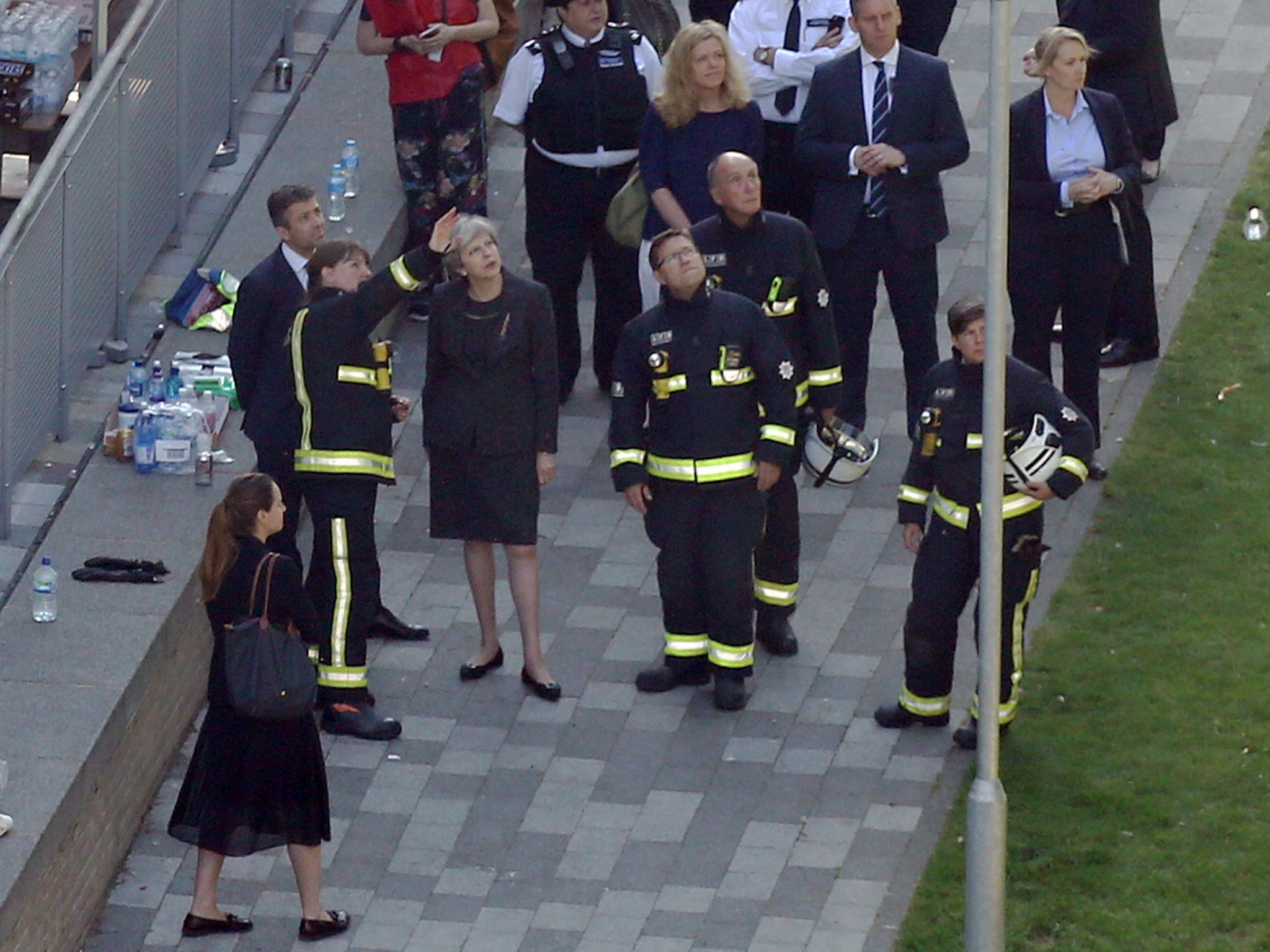 Theresa May with firefighters outside Grenfell Tower the day after the fire