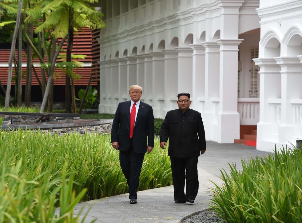 Kim Jong-un and Donald Trump walk together during a break in talks at their historic US-North Korea summit