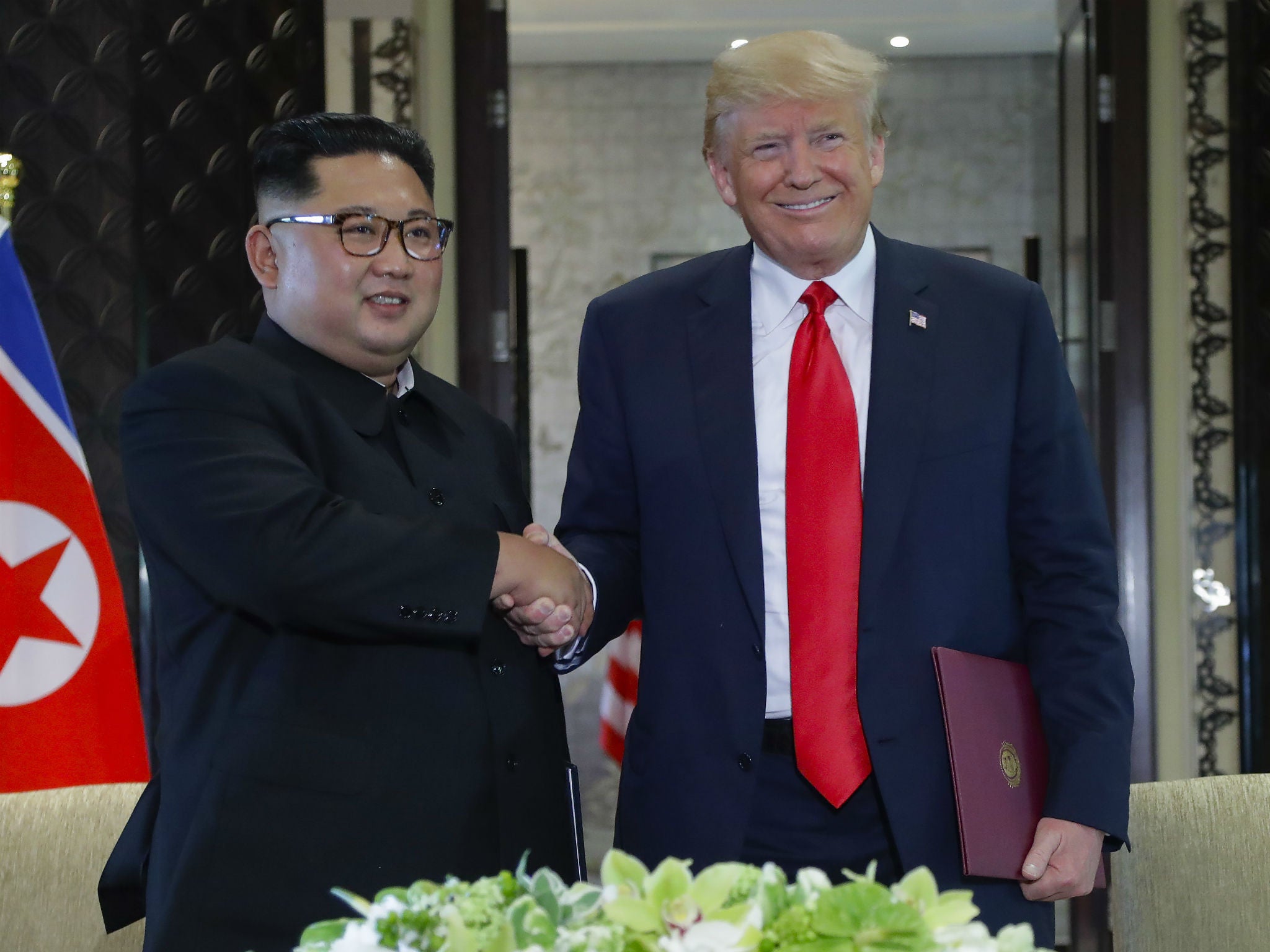 North Korea leader Kim Jong-un and President Donald Trump shake hands after a document signing at the Capella resort in Singapore