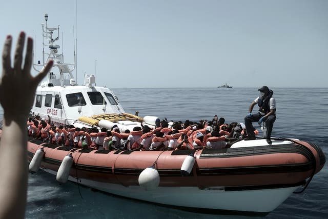 Stranded migrants on a coastguard boat as they are transferred from the Aquarius to Italian ships to continue the journey to Spain