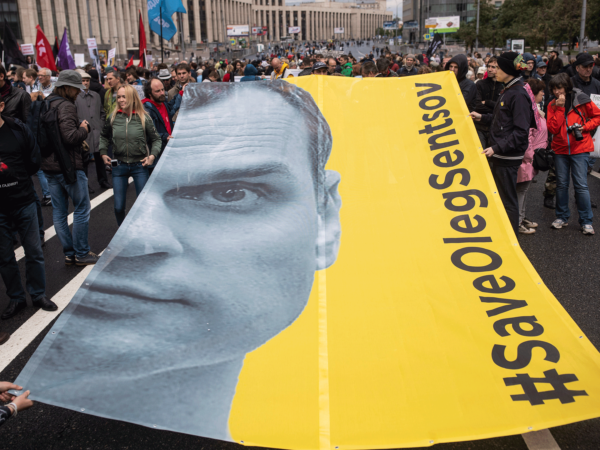 Protesters hold a poster with the image of political prisoner Oleg Sentsov during an opposition rally organised by Free Russia in Moscow
