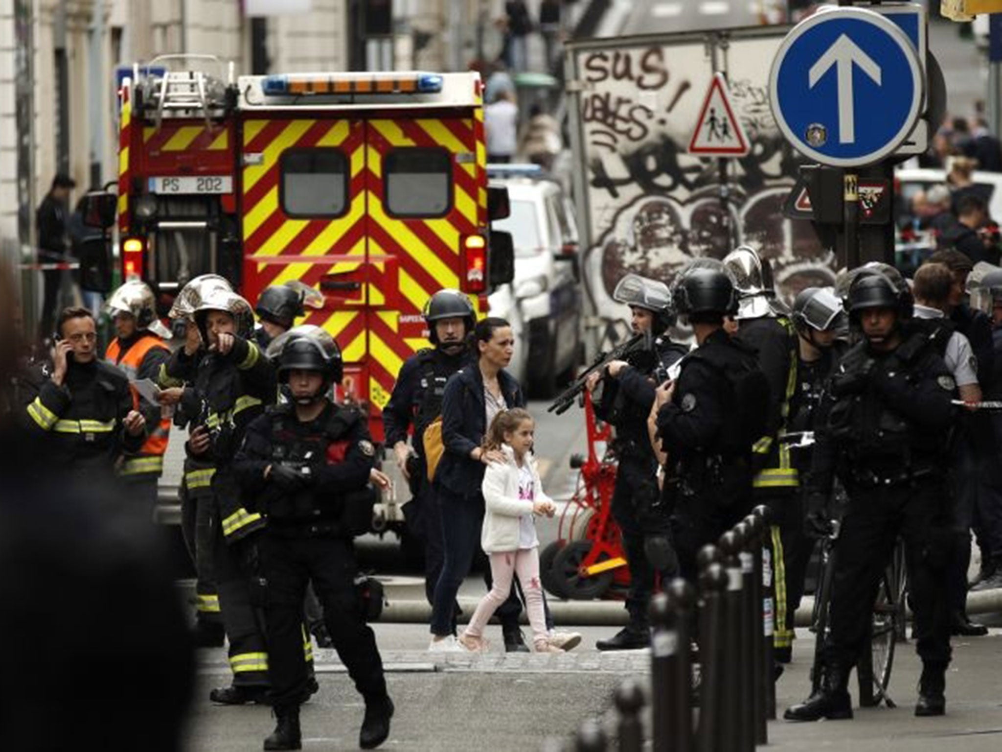 A woman and a young girl are evacuated by police forces during a hostage taking situation in Rue des Petites Ecuries, in Paris, France