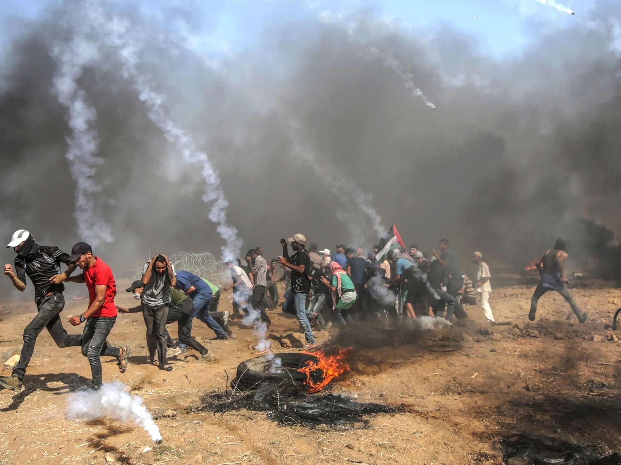 Palestinian protesters run for cover from Israeli teargas during clashes last week