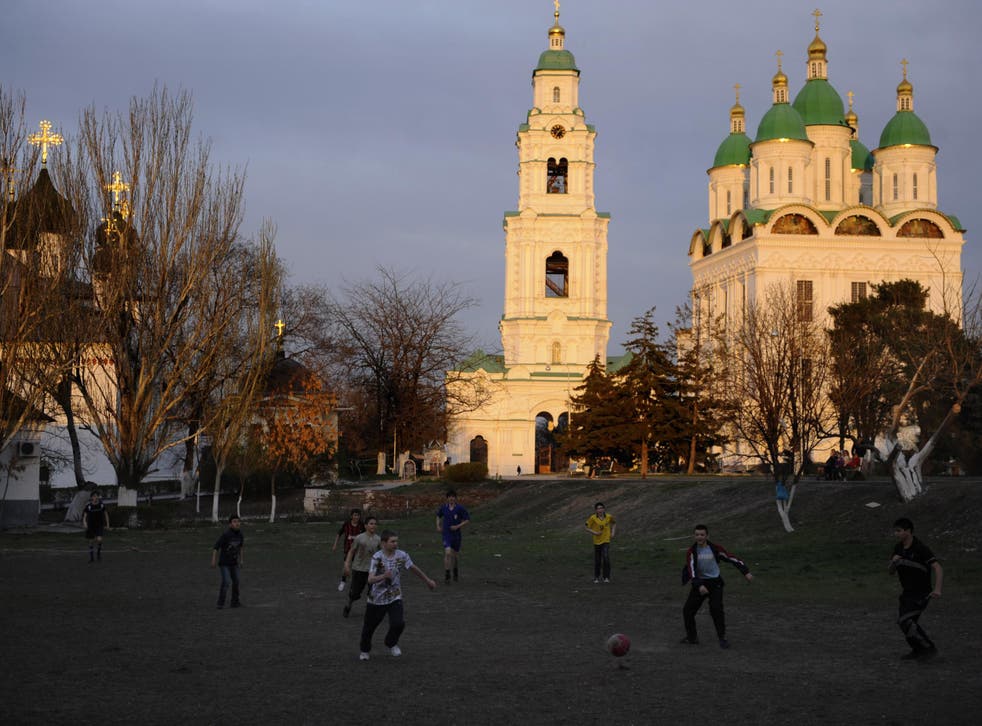 Children play football near an Orthodox cathedral in the southern Russian city of Astrakhan