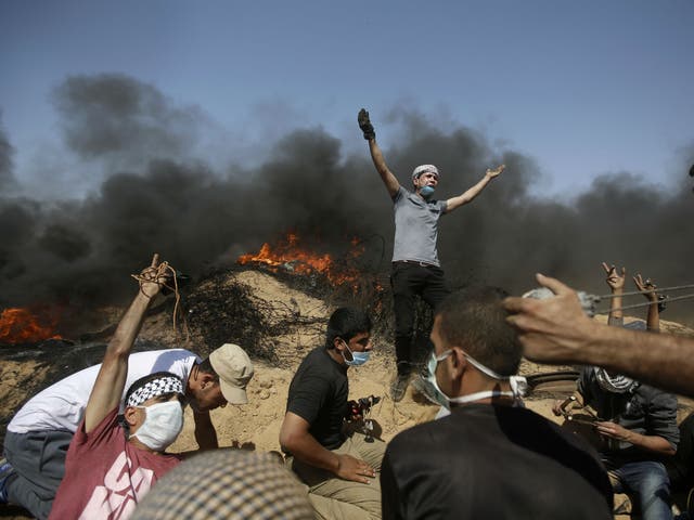 Palestinians take cover near the Gaza Strip's border with Israel during a protest in the Gaza Strip