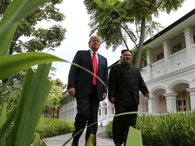 Donald Trump and Kim Jong-un walk together before their working lunch during their summit in Singapore