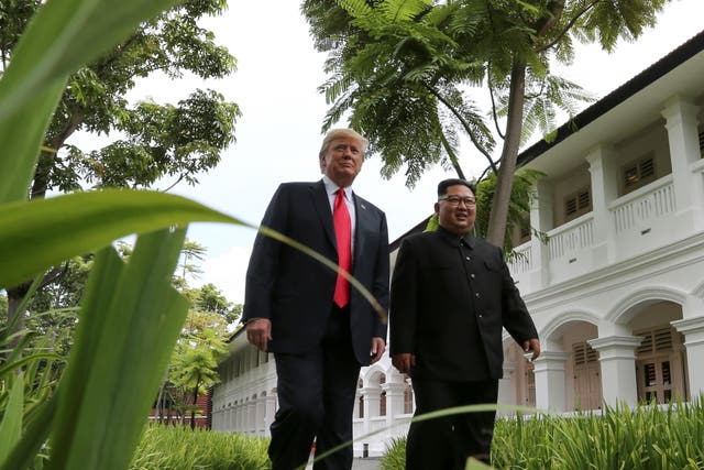 Donald Trump and Kim Jong-un walk together before their working lunch during their summit in Singapore