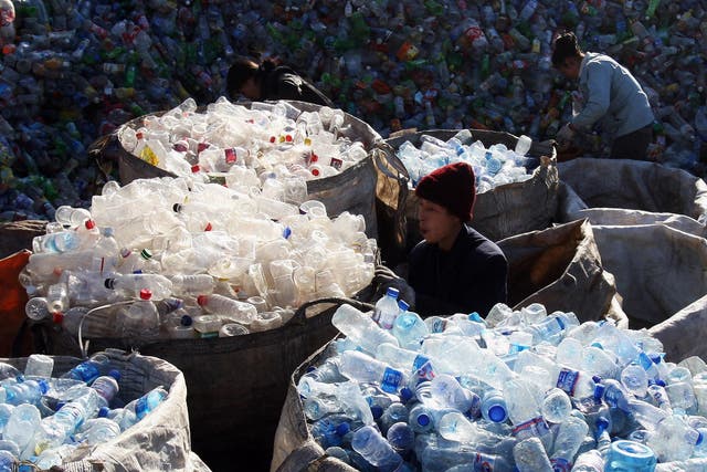 Labourers collect assorted plastic products from a garbage pile at a recycling center on the outskirts of the city on December 17, 2008 in Beijing, China
