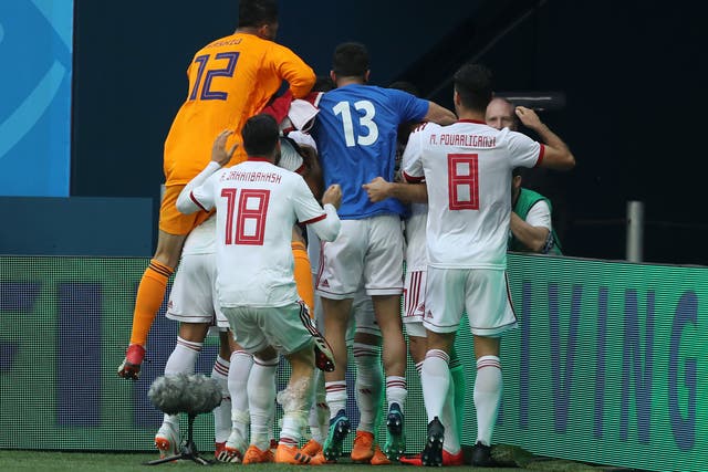 Iran players celebrate the own goal by Aziz Bouhaddouz