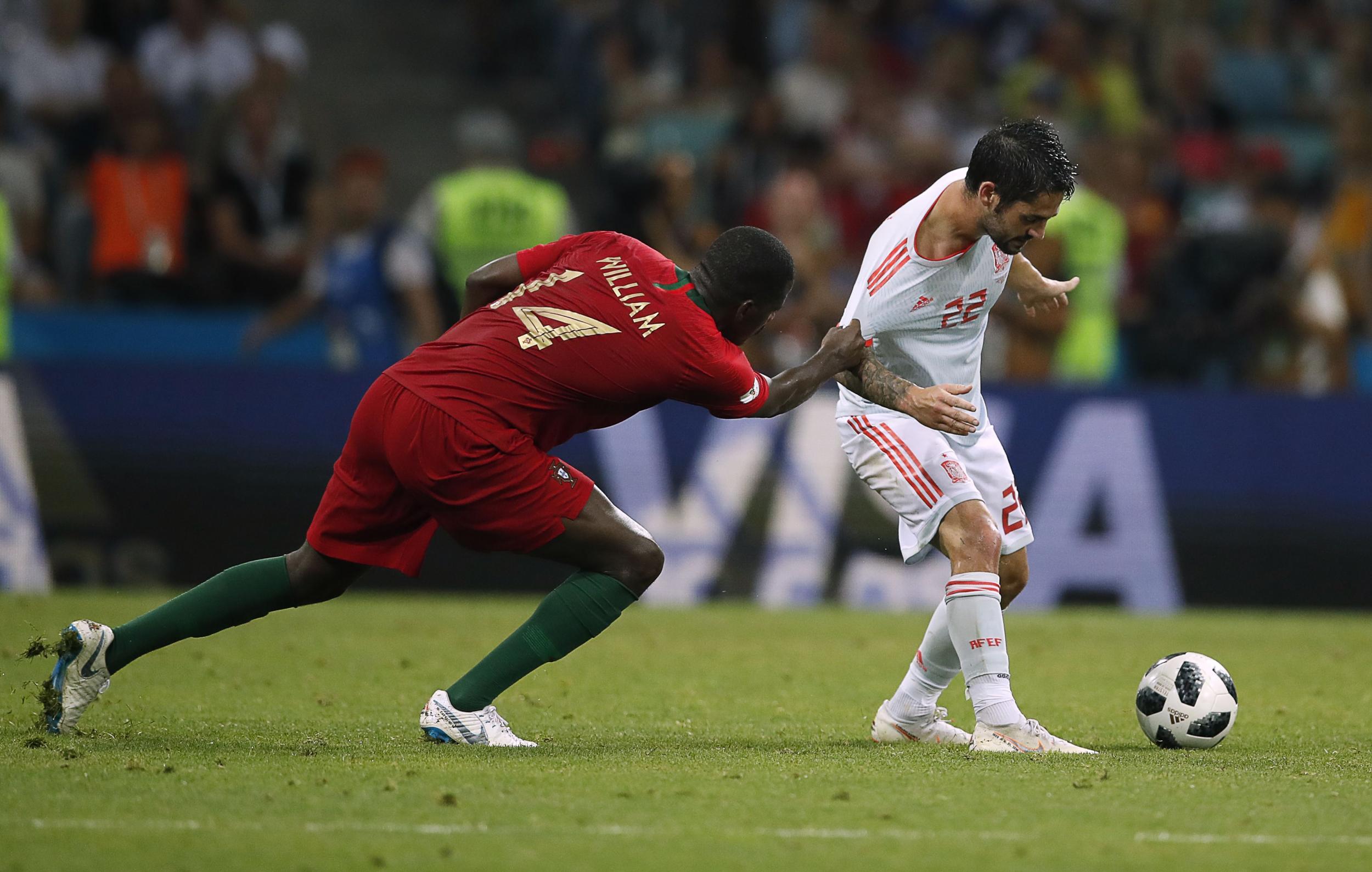 William Carvalho tries to keep hold of Isco