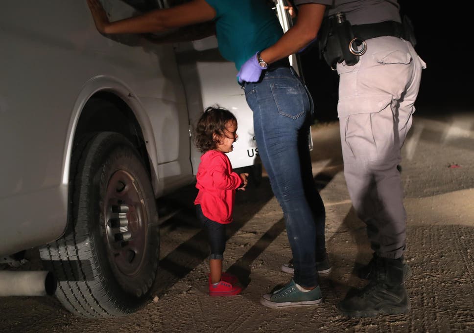 A two-year-old Honduran asylum seeker cries as her mother is searched and detained near the U.S.-Mexico border