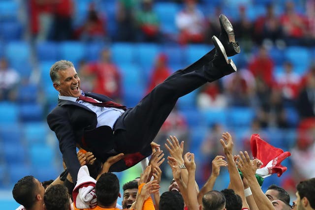 Iran players celebrate victory by throwing head coach Carlos Queiroz in the air
