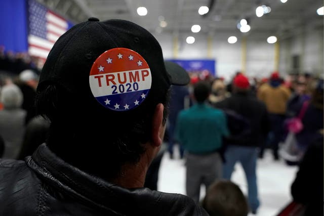 A man wears a Trump 2020 campaign button as US President Donald Trump speaks during a Make America Great Again rally in Pennsylvania, 10 March 2018.