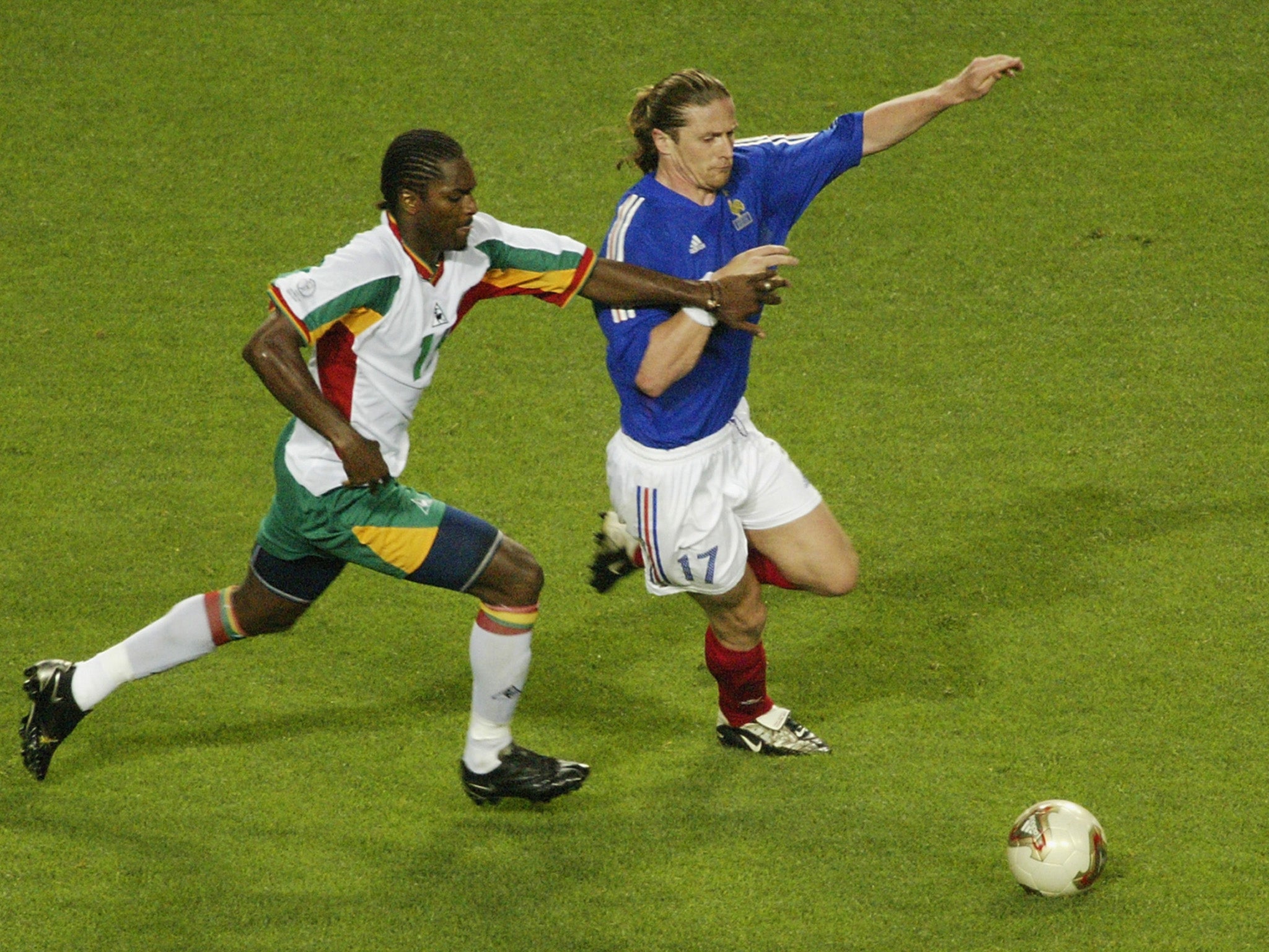 Salif Diao tussles for possession with Emmanuel Petit during France vs Senegal