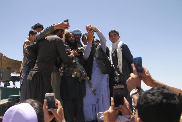 Taliban militants meets Afghan people during a visit to Ghazni on the on second day of a three-day ceasefire to mark Eid al-Fitr