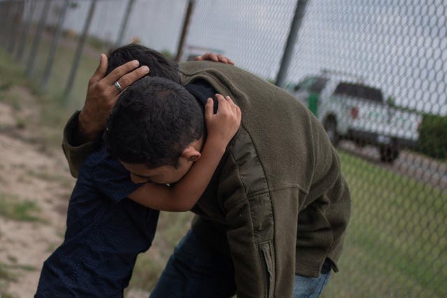 A four-year-old boy weeps in the arms of a family member as he and others were apprehended by border patrol agents after illegally crossing into the US from Mexico near McAllen, Texas, May 2, 2018.