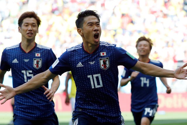 Japan's midfielder Shinji Kagawa celebrates with teammates after scoring a penalty