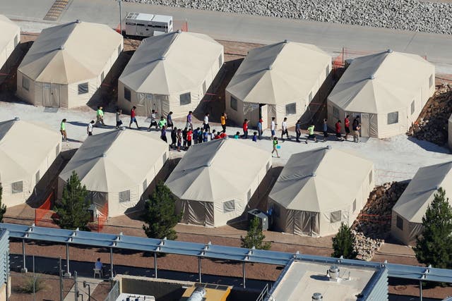 Immigrant children, many of whom have been separated from their parents under a new 'zero tolerance' policy by the Trump administration, are shown walking in single file between tents in their compound next to the Mexican border in Tornillo, Texas