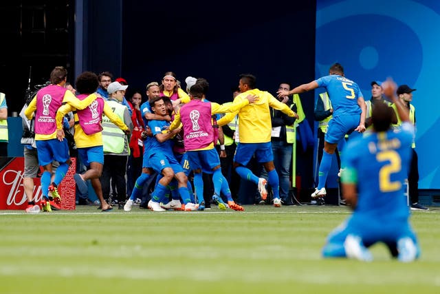 Brazil's Philippe Coutinho, centre, is embraced by his teammates as they celebrate his team's first goal during the group E match between Brazil and Costa Rica