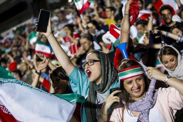 Women cheer on the Iranian national team during their Group B match against Sp