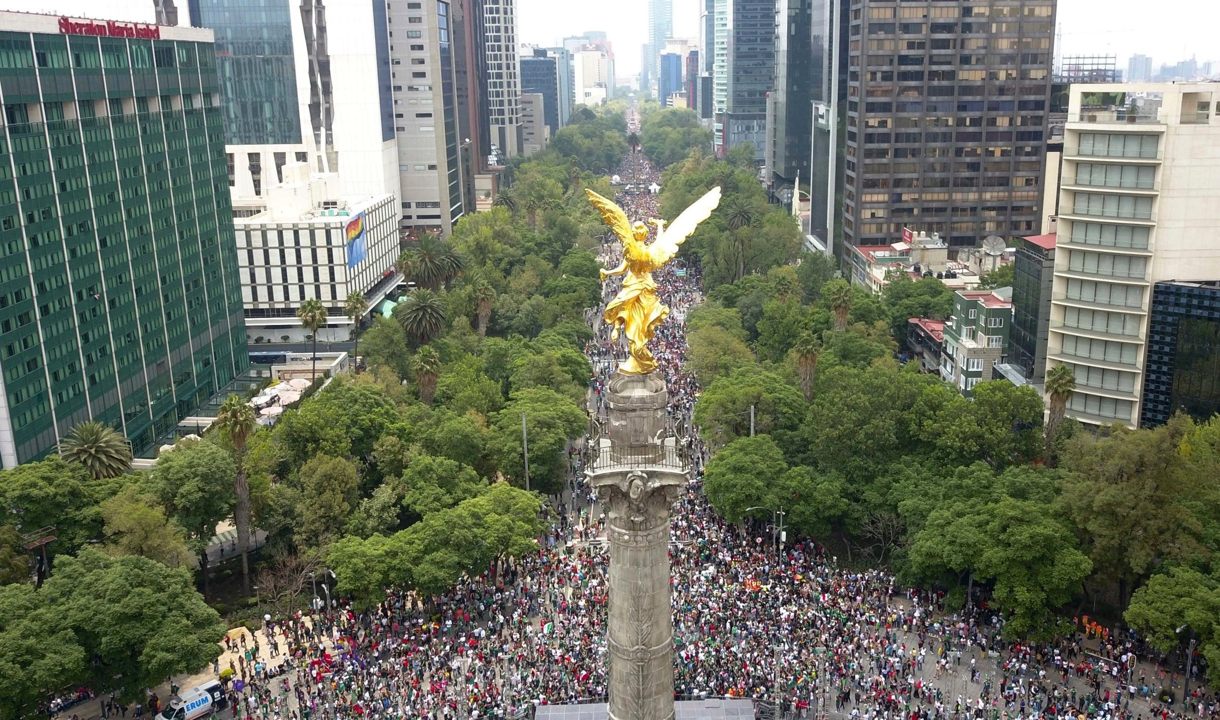 Thousands of soccer fans and Gay Pride revellers converge on Mexico City's Angel of Independence on Reforma Avenue