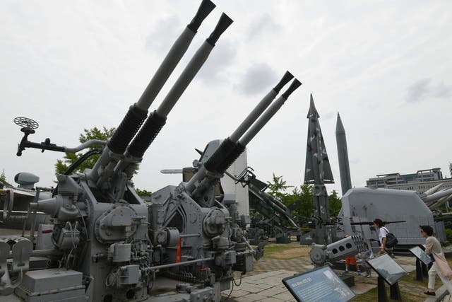Visitors walk past weapons displayed at the Korean War Memorial in Seoul