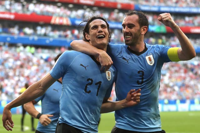 Edinson Cavani of Uruguay celebrates with teammate Diego Godin after scoring his team's third goal