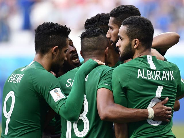 Saudi Arabia's midfielder Salman Al-Faraj (obscured) is congratulated by teammates