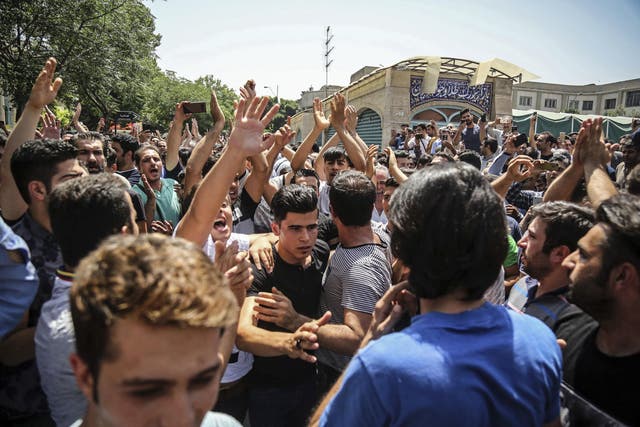 A group of protesters chant slogans at the main gate of old grand bazaar in Tehran, Iran, on 25, June 2018