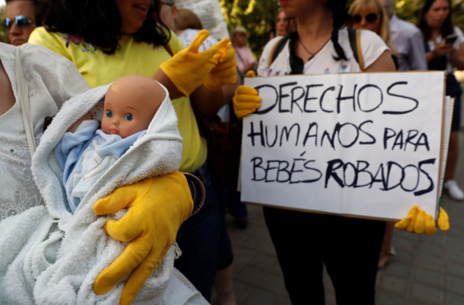 A protester holds a placard reading ‘Humans rights for stolen babies’, as victims of the alleged snatched babies plot protest outside the Provincial Court in Madrid