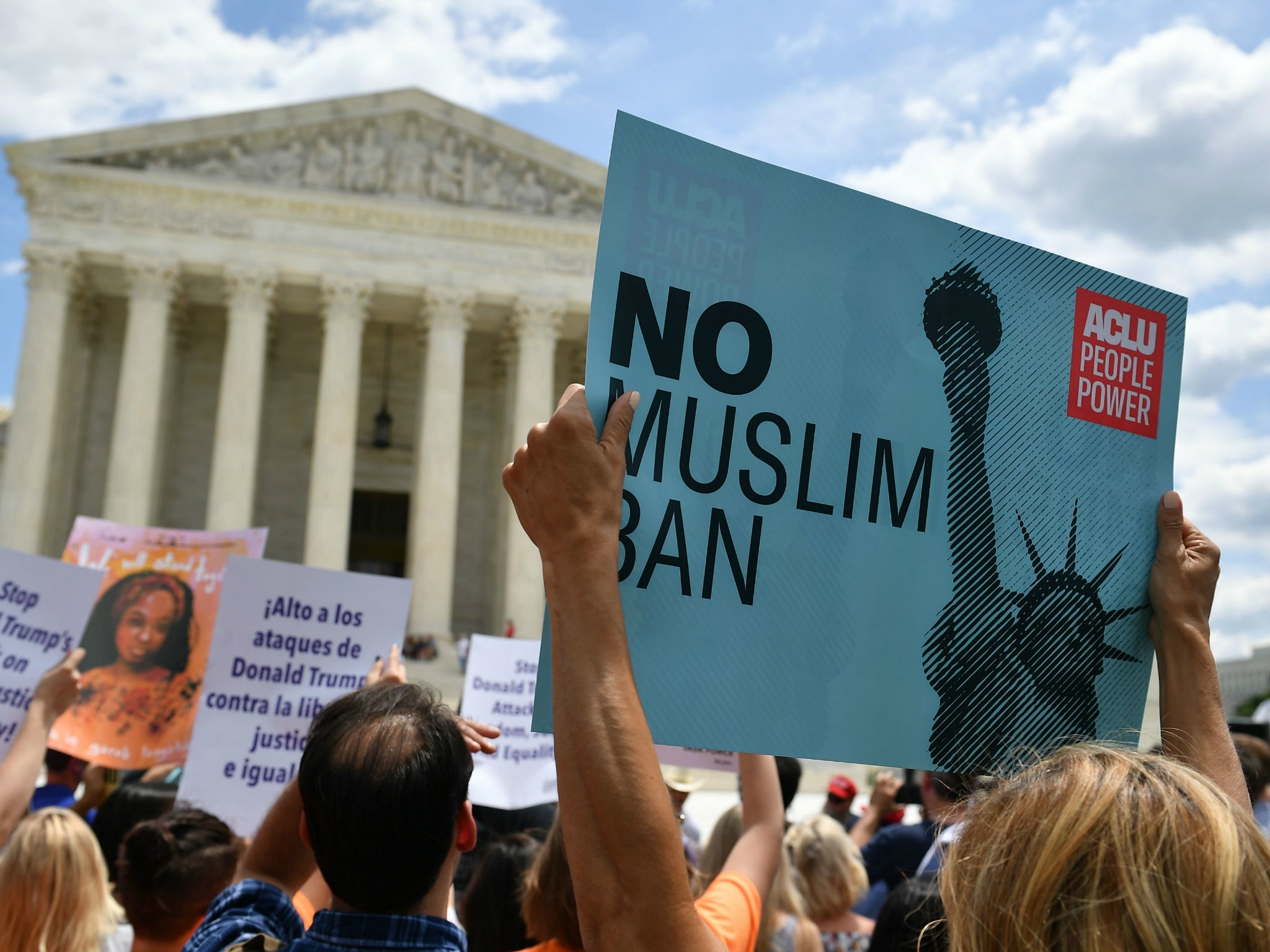 People protest the Muslim travel ban outside of the US Supreme Court in Washington, DC on 26 June 2018 just before the court upheld Donald Trump's travel ban.