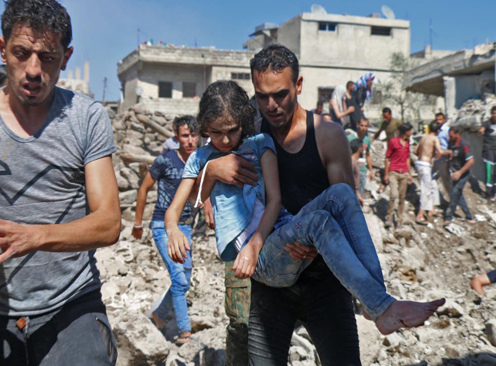 A man carries a child rescued from rubble after Syrian regime and Russian air strikes in the rebel-held town of Nawa, about 20 miles north of Deraa