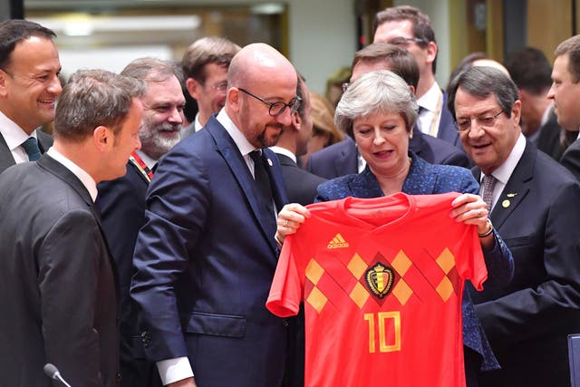  Theresa May is presented with a Belgian football shirt by Charles Michel, the Belgian prime minister, at the European Council in Brussels