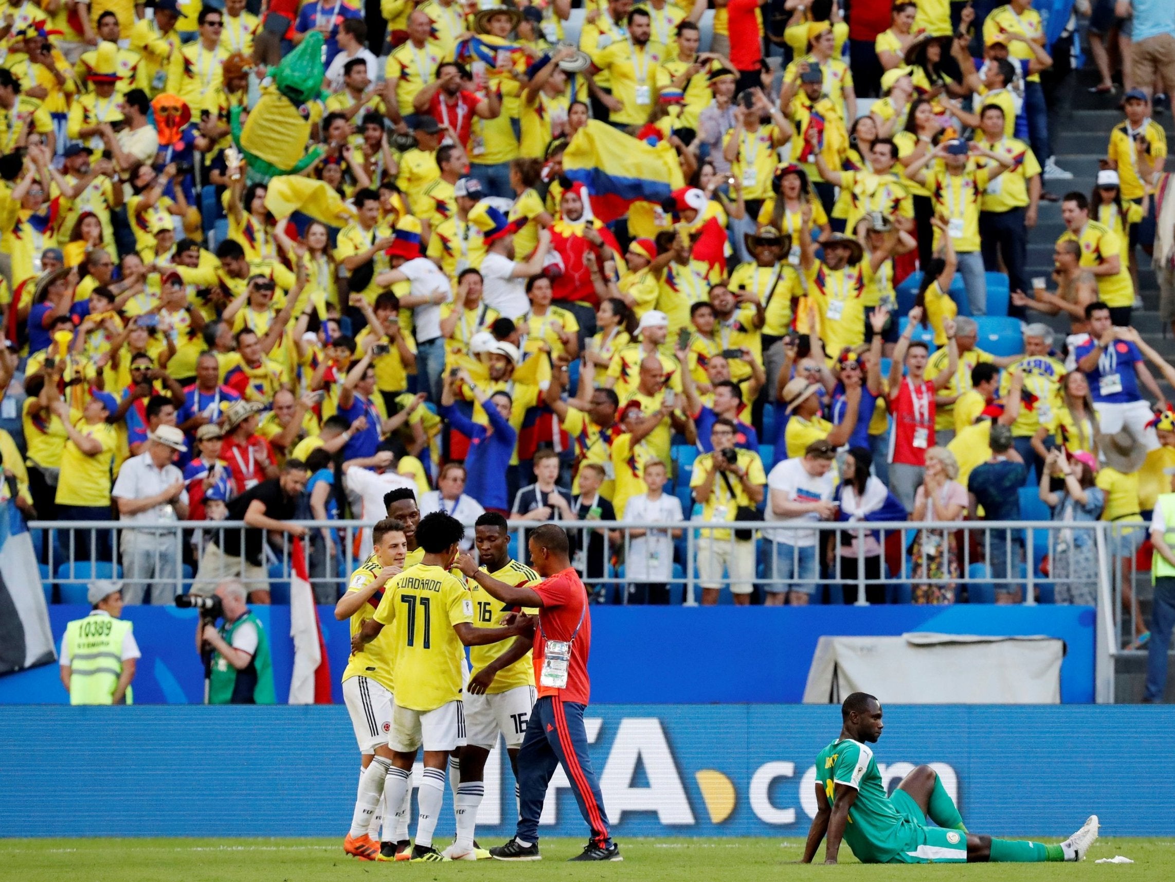 Colombia players celebrate as Senegal's Moussa Konate looks dejected after the match