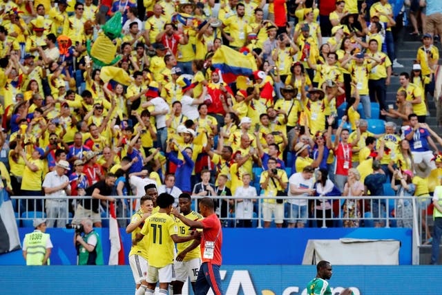 Colombia players celebrate as Senegal's Moussa Konate looks dejected after the match