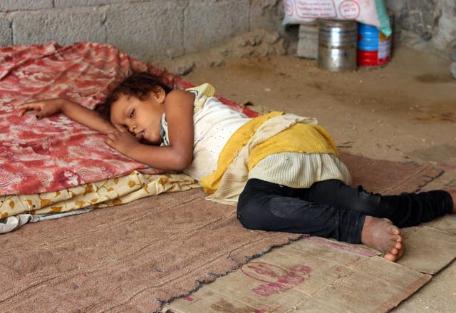A girl who fled with her family from Hodeidah to Abs rests at a makeshift camp for displaced people