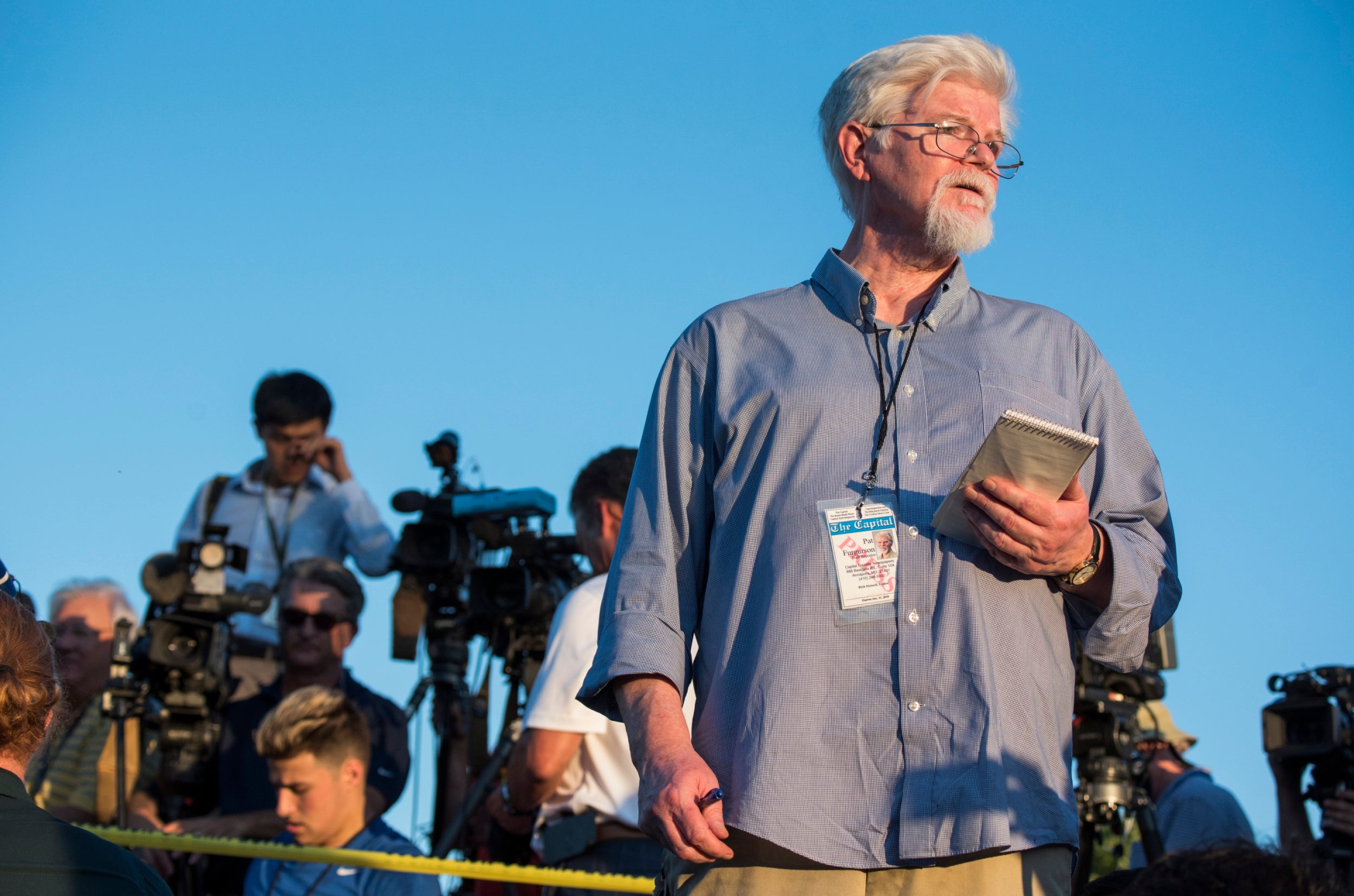 Pat Furguson, staff reporter at the Capital Gazette, reports outside the scene of the shooting on Thursday (EPA)