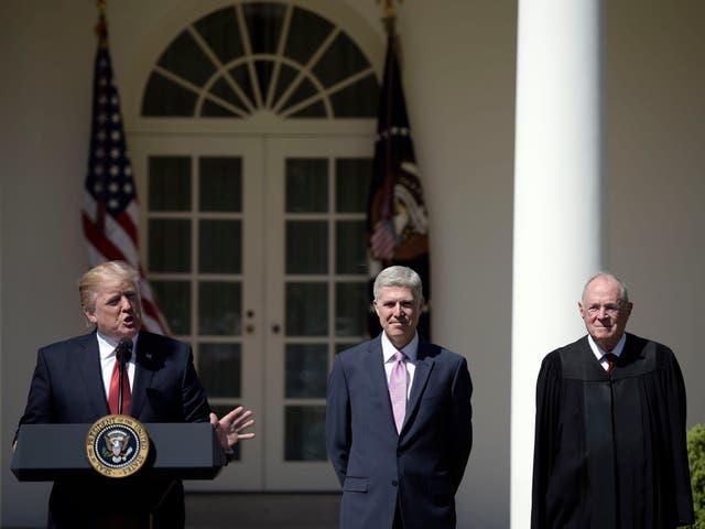 Donald Trump speaks before Justice Anthony Kennedy (R) administers the oath of office to Neil Gorsuch (C) as an associate justice of the US Supreme Court