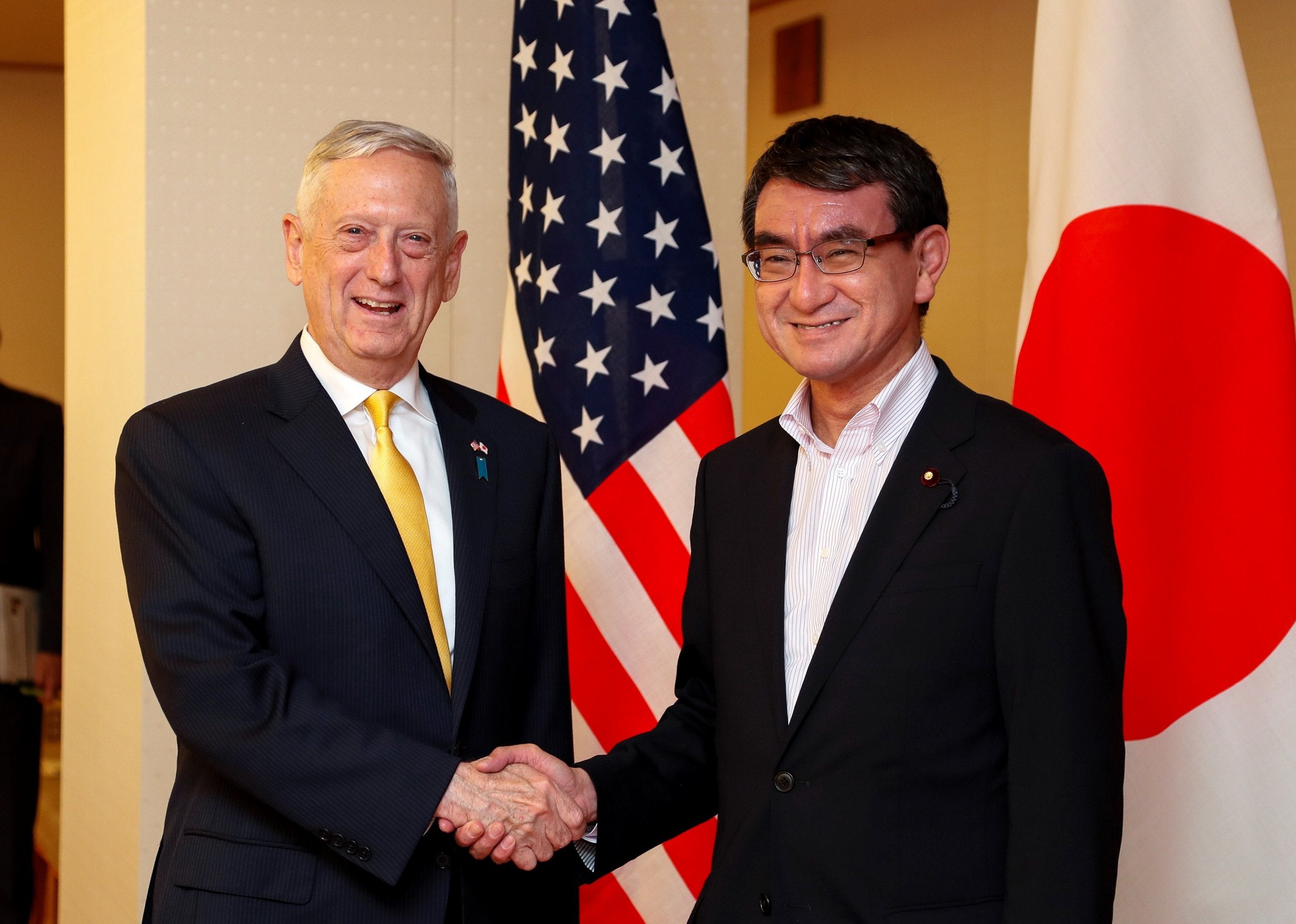 James Mattis, the US secretary of defence, shakes hands with Japan's foreign minister, Taro Kono, in Tokyo