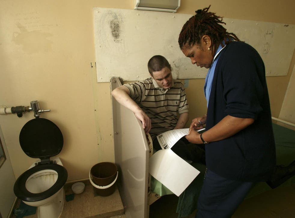 A nurse speaks to an inmate in his cell at Pentonville Prison.