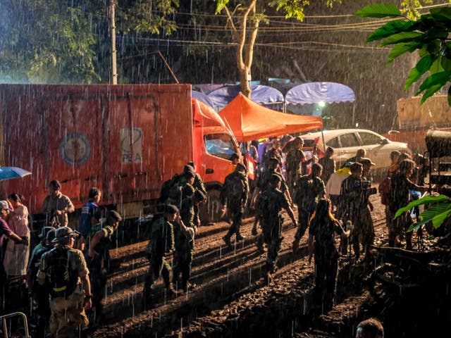 Policemen in the rain at Tham Luang Nang Non cave where the football team have gone missing