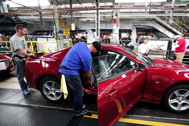 Workers put the finishing touches on a new General Motors 2016 Chevrolet Camaro at Lansing Grand River Assembly Plant in Lansing, Michigan on 26 October 2015