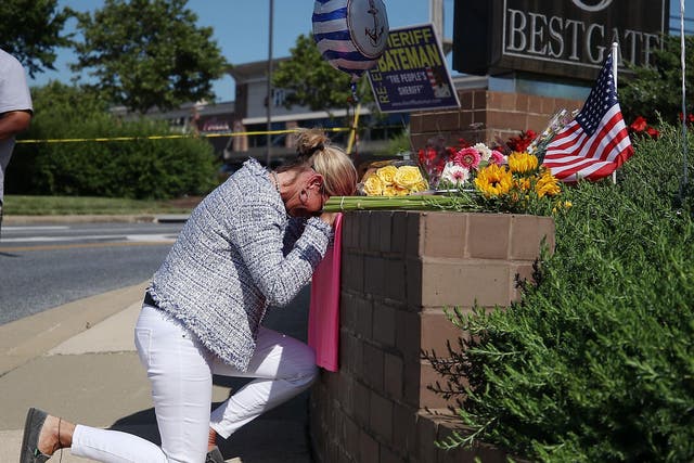 Lynne Griffin pays her respects at a makeshift memorial near the Capital Gazette where 5 people were shot and killed by a gunman on Thursday
