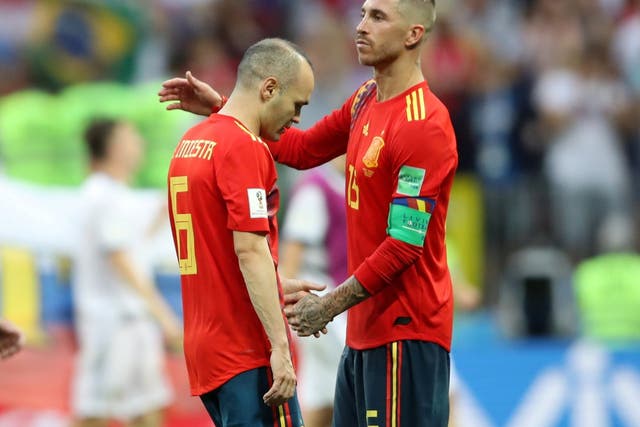 Andres Iniesta is consoled by Sergio Ramos