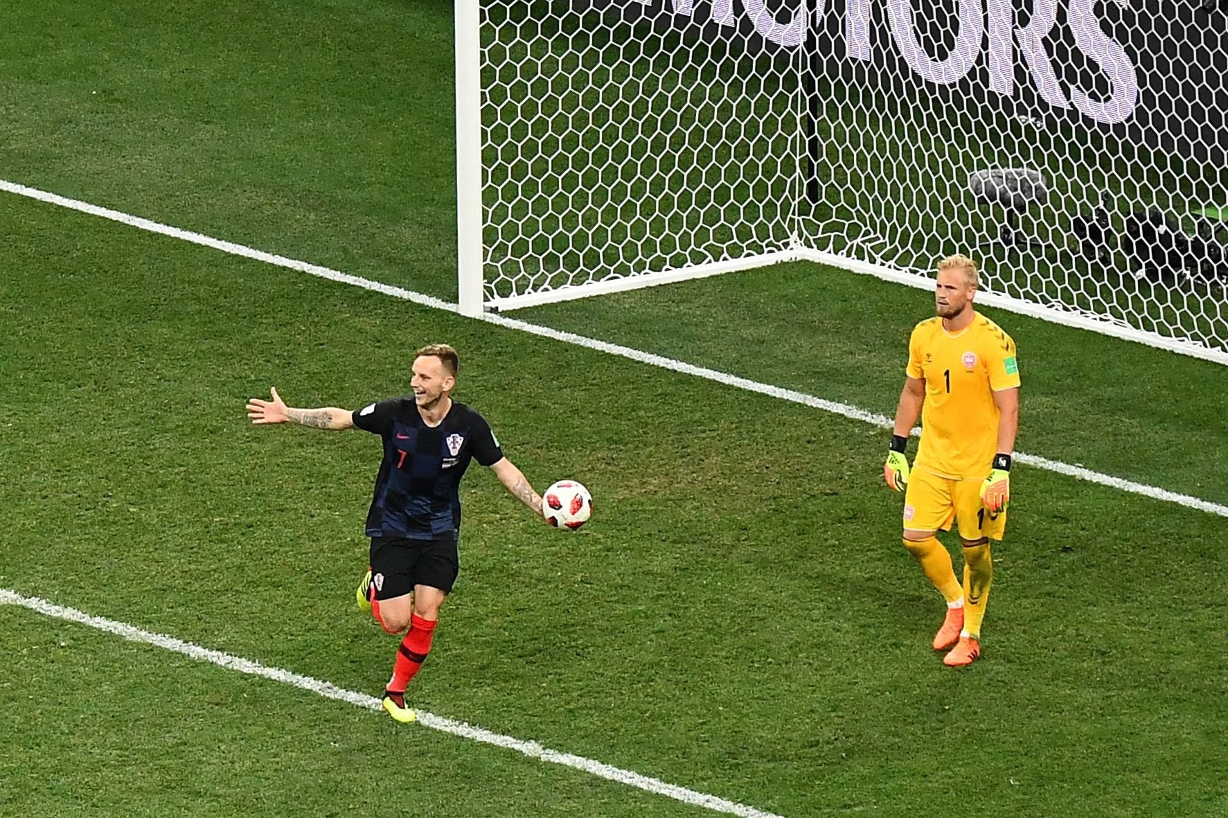 Croatia's midfielder Ivan Rakitic (L) celebrates after scoring the decisive penalty